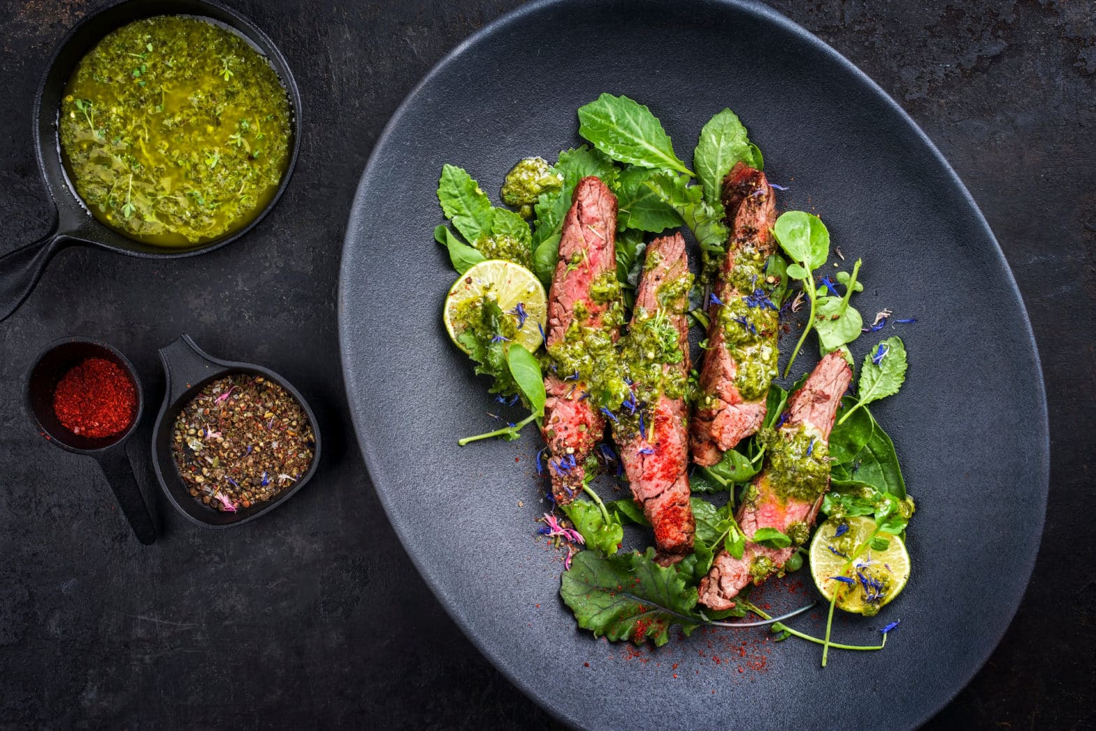 Steak with Chimichurri Sauce on a dark plate